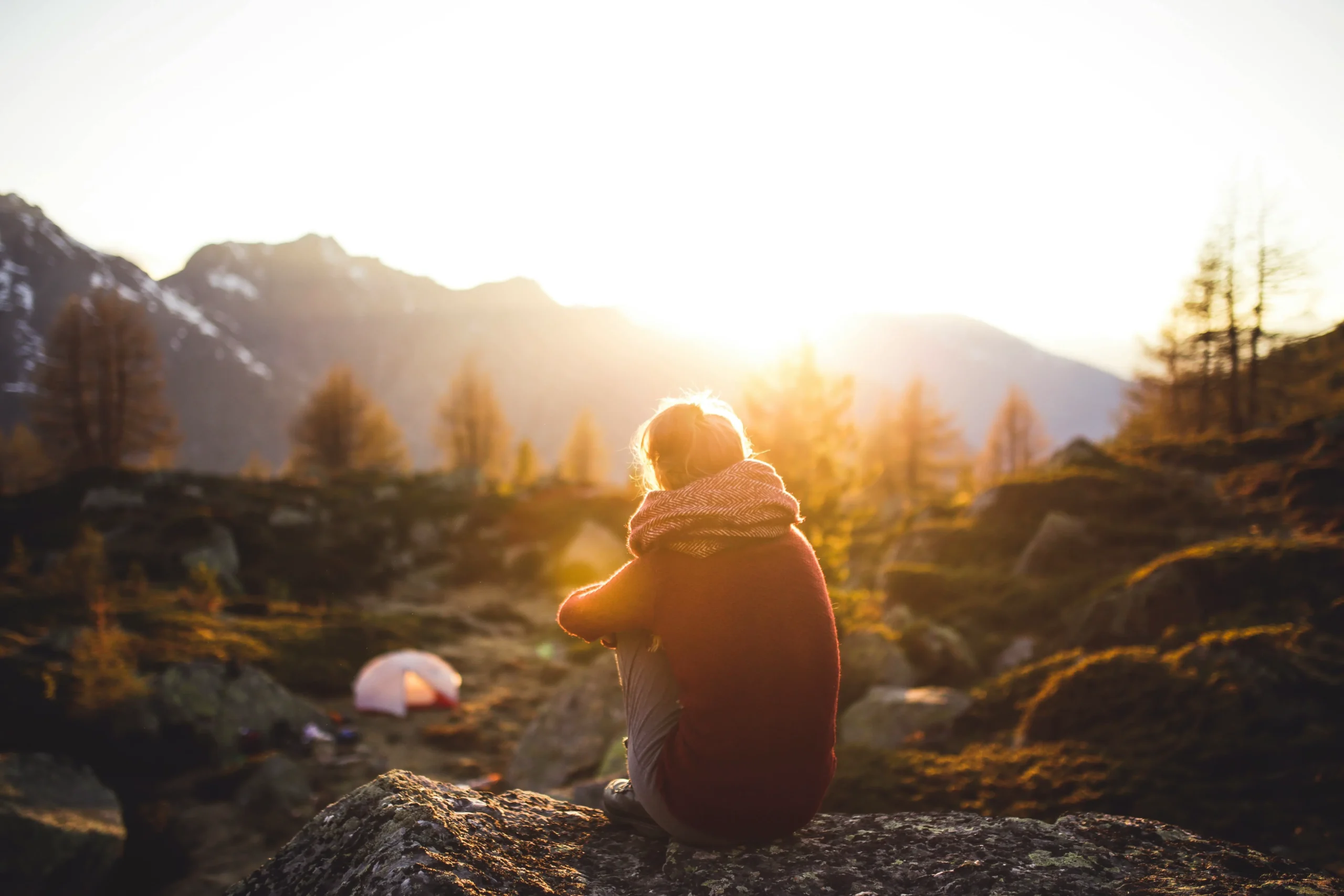 Personne assise dans la nature au coucher du soleil, méditant, illustrant la paix intérieure obtenue par l’hypnothérapie à Jeumont